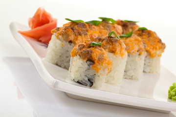 Japanese Cuisine - Appetizing Salmon Sushi Set. Philadelphia Sushi Roll - Maki Sushi with Philadelphia Cheese inside on mirror black background. Smoked salmon rolls served on a plate