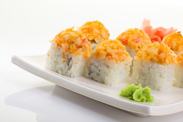 Japanese Cuisine - Appetizing Salmon Sushi Set. Philadelphia Sushi Roll - Maki Sushi with Philadelphia Cheese inside on mirror black background. Smoked salmon rolls served on a plate