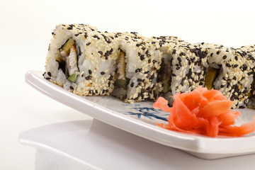 Japanese Cuisine - Appetizing Salmon Sushi Set. Philadelphia Sushi Roll - Maki Sushi with Philadelphia Cheese inside on mirror black background. Smoked salmon rolls served on a plate