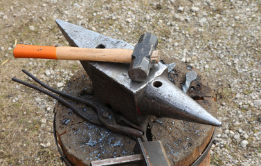 heavy anvil and a hammer in the shop of blacksmith