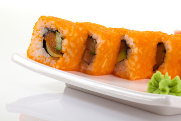 Japanese Cuisine - Appetizing Salmon Sushi Set. Philadelphia Sushi Roll - Maki Sushi with Philadelphia Cheese inside on mirror black background. Smoked salmon rolls served on a plate
