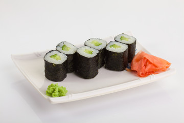 Japanese Cuisine - Appetizing Salmon Sushi Set. Philadelphia Sushi Roll - Maki Sushi with Philadelphia Cheese inside on mirror black background. Smoked salmon rolls served on a plate