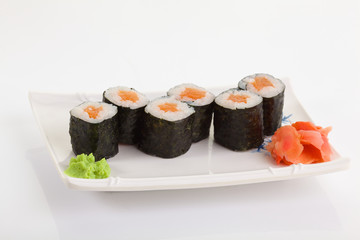 Japanese Cuisine - Appetizing Salmon Sushi Set. Philadelphia Sushi Roll - Maki Sushi with Philadelphia Cheese inside on mirror black background. Smoked salmon rolls served on a plate