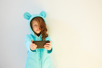 Cheerful Little Girl 7 years old make a Selfie on the White Background. Concept Social Media Addiction.