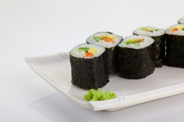 Japanese Cuisine - Appetizing Salmon Sushi Set. Philadelphia Sushi Roll - Maki Sushi with Philadelphia Cheese inside on mirror black background. Smoked salmon rolls served on a plate