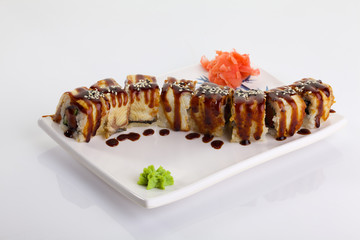 Japanese Cuisine - Appetizing Salmon Sushi Set. Philadelphia Sushi Roll - Maki Sushi with Philadelphia Cheese inside on mirror black background. Smoked salmon rolls served on a plate