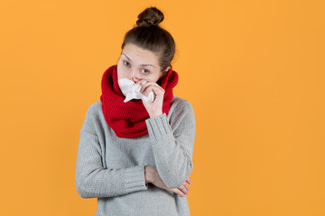 sickly-looking girl holds a napkin near her nose and looks at the camera