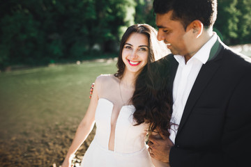 Naklejka premium Wedding couple, groom and bride hugging, outdoor near river