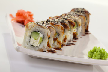 Japanese Cuisine - Appetizing Salmon Sushi Set. Philadelphia Sushi Roll - Maki Sushi with Philadelphia Cheese inside on mirror black background. Smoked salmon rolls served on a plate