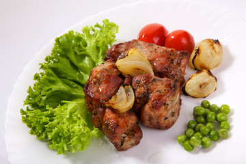 Appetizing stake with vegetables. Shish kebab isolated on white background