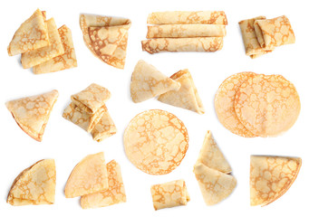 Set of delicious thin pancakes on white background, top view