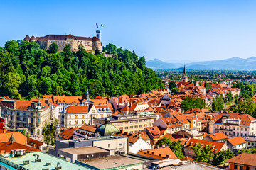 Old town and the medieval Ljubljana castle on top of a forest hill in Ljubljana, Slovenia - obrazy, fototapety, plakaty
