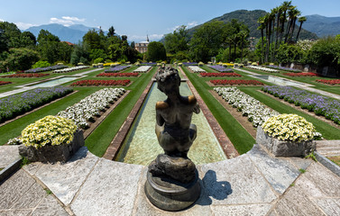 Landscape of Botanical Gardens of Villa Taranto with bronze statue The Fisher in front, Pallanza, Verbania, Italy