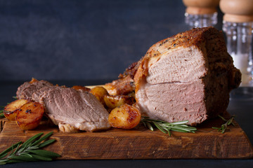 Roast leg of lamb with potatoes and rosemary on dark background. horizontal image, copy space © freeskyline