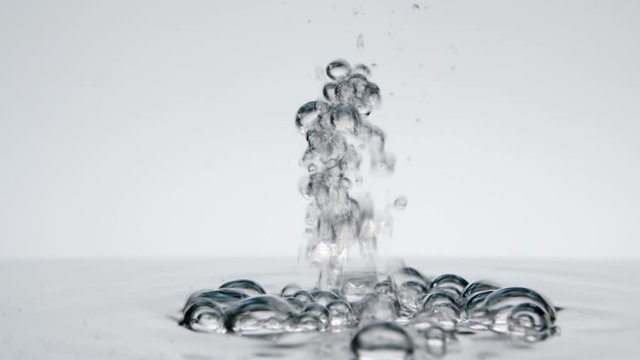 Pouring water with air bubbles and splashes on white background, water flowing, underwater bubbles
