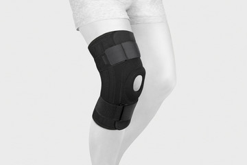 Knee Support Brace on leg isolated on white background. Orthopedic Anatomic Orthosis. Braces for...