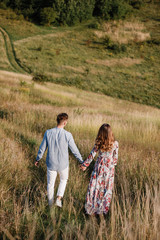 loving couple hold hands and walk outside in the field. Concept of love and family. copy space