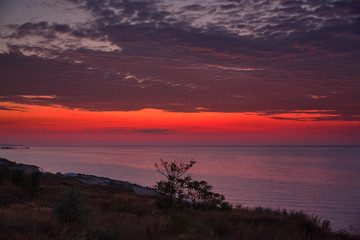 Fototapeta na wymiar Beautiful red dawn on the coast of the sea. Seascape.