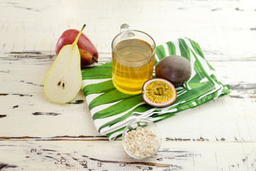Still life with tea, pear, oats and passion fruit. Top view. On a beautiful vintage table with a...