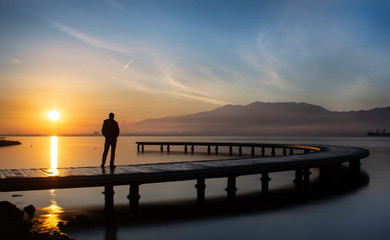 Fototapeta premium silhouette of man on the pier at sunset