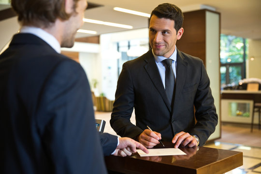 Businessman checking out in hotel.