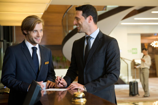 Businessman checking out in hotel reception.