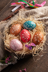 Colorful Easter eggs decorated with wax in a basket