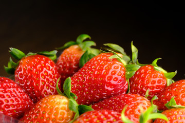 Close up of stack of strawberry isolated on black 