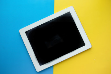 top view of digital tablet on color background.