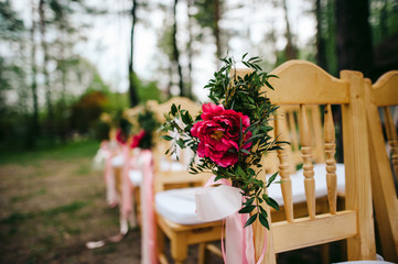 decoration of wedding chairs with pink peonies and ribbons