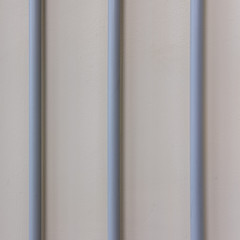 Lines of electrical wires in round plastic pipes on the wall