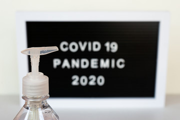 poster with the words COVID19 pandemic 2020, with a bottle of alcohol gel as a sign of prevention