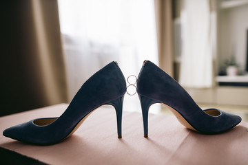 Shoes on high heels and wedding rings
