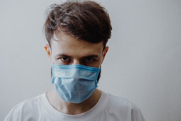 Portrait of a man in a medical mask during the coronavirus epidemic. symptoms of a dangerous viral disease: sore throat, cough, fever