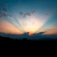 Obraz premium Sun rising behind cloudy sky