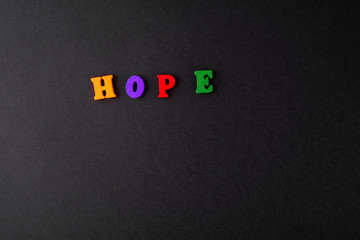 A word hope of multicolored wooden letters on a black background.