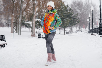 A young athletic girl poses on a frosty and snowy day. Fitness, running