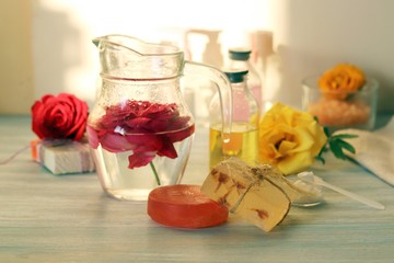Fresh roses, soap, petals, water and oil on the table for the preparation of natural cosmetics, spa, hygiene procedures, healthy lifestyle