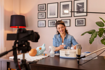Fototapeta premium Midwife making video about baby bottles sterilizing