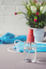 Antibacterial antiseptic in a transparent bottle on the background of protective medical masks and gloves. The concept of prevention and protection against viruses and diseases.