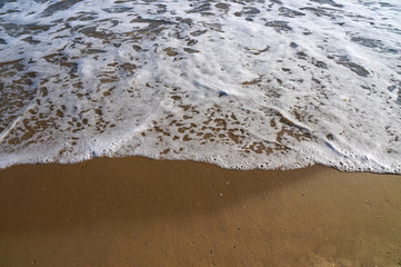 white light waves and yellow sand