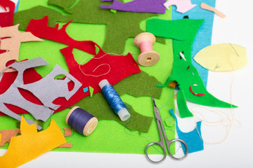 Colored felt, thread, needles and scissors on the table