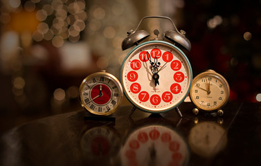 Vintage alarm clocks on table with rich bokeh in background.
