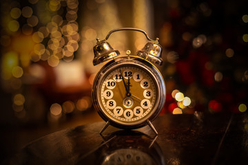 Vintage alarm clocks on table with rich bokeh in background.