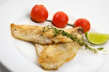Appetizing grilled fish with vegetables isolated on white background