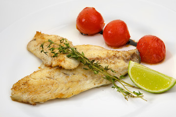 Appetizing grilled fish with vegetables isolated on white background