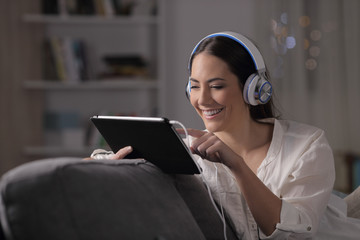 Happy woman browsing media in the night at home