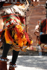 At a Navajo dance in Arizona this dancer is wearing traditional clothing in bright orange colours.