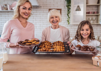 Daughter, mother and grandmother cooking on kitchen. Women generation baking together.
