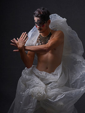 Paloma ave, Joven maquillado y disfrazado de joker con labios negros mascara en forma de arte y coloso de cara con vestuario de nailon reciclado con expresión melancólica